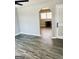 A spacious living room featuring modern gray wood flooring, a doorway, and light gray walls at 23 Hampton Locust Grove Rd, Hampton, GA 30228