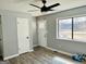 A well-lit living room features a ceiling fan, gray wood flooring, and view of the backyard at 23 Hampton Locust Grove Rd, Hampton, GA 30228