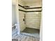 Tiled shower featuring black trim, rainfall shower head, handheld sprayer, and decorative pebble floor at 23 Hampton Locust Grove Rd, Hampton, GA 30228