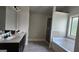 Bathroom featuring a tub, separate glass enclosed shower, and double vanity at 207 Birchwood Dr, Loganville, GA 30052