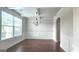 Formal dining room with large windows, decorative chandelier, and classic wainscoting at 207 Birchwood Dr, Loganville, GA 30052