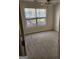 Bedroom featuring neutral carpet, ceiling fan, and a large window with blinds providing natural light at 3874 Austin Park Ne Ln, Decatur, GA 30032