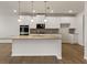 Modern kitchen with granite island, white cabinets, and stainless steel appliances at 275 Arwen Dr # 68, Mcdonough, GA 30252