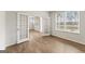 Open-concept room with wood floors, white walls, windows, and glass-paneled doors at 275 Arwen Dr # 68, Mcdonough, GA 30252