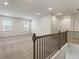 Loft area with carpet, two windows for natural light and a view of the staircase at 275 Arwen Dr # 68, Mcdonough, GA 30252