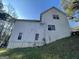 Side view of a house with a partially visible basement, light siding, and several windows at 4078 Kings Cswy, Ellenwood, GA 30294