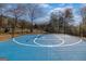 Full basketball court with blue surface surrounded by fencing and trees at 1408 Hemphill Rd, Stockbridge, GA 30281