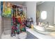 Bathroom with a glass vessel sink, colorful shower curtain and a round mirror at 1408 Hemphill Rd, Stockbridge, GA 30281