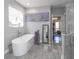 Luxurious bathroom boasts a soaking tub, stylish fixtures, and a glass-enclosed shower, plus an adjoining closet at 1408 Hemphill Rd, Stockbridge, GA 30281