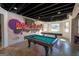 The expansive game room includes a pool table, shuffleboard, and colorful wall art at 1408 Hemphill Rd, Stockbridge, GA 30281