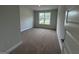 Carpeted bedroom with a window offering views of the front yard, and neutral paint adding to the welcoming feel at 5311 Tuscany Dr # 98 Plapprox Sqft, Douglasville, GA 30135