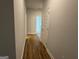 Long hallway with wood floors, painted white doors and trim, and access to the carpeted bedrooms at 5311 Tuscany Dr # 98 Plapprox Sqft, Douglasville, GA 30135