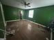 This living room has freshly painted green walls, hardwood floors, and a ceiling fan at 1721 Lisbon Sw Dr, Atlanta, GA 30310