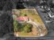 Aerial view of charming home with bright red roof surrounded by greenery and large yard at 1713 Bramlett Shoals Rd, Lawrenceville, GA 30045