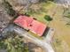 An aerial view of a charming home with a red roof surrounded by lush greenery and mature trees at 1713 Bramlett Shoals Rd, Lawrenceville, GA 30045