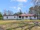 Back exterior view shows a red roof, white siding, and a chain link fence at 1713 Bramlett Shoals Rd, Lawrenceville, GA 30045