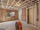 Unfinished basement with insulation and a window showing the wooded outdoors at 1713 Bramlett Shoals Rd, Lawrenceville, GA 30045
