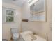 Bathroom featuring sink, toilet, mirror and natural light from the window at 1713 Bramlett Shoals Rd, Lawrenceville, GA 30045