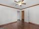 Bedroom features hardwood floors, white walls, ceiling fan and closet with an adjacent room at 1713 Bramlett Shoals Rd, Lawrenceville, GA 30045