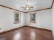 Bedroom with hardwood floors, ceiling fan, wood trim, and two windows for natural light at 1713 Bramlett Shoals Rd, Lawrenceville, GA 30045