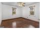 Bedroom featuring a ceiling fan, hardwood floors, and two windows for natural light at 1713 Bramlett Shoals Rd, Lawrenceville, GA 30045