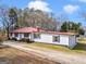Aerial shot captures the home's red metal roof, long driveway, and surrounding trees at 1713 Bramlett Shoals Rd, Lawrenceville, GA 30045