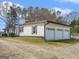 Exterior side shot of the home shows a three car garage and gravel driveway at 1713 Bramlett Shoals Rd, Lawrenceville, GA 30045