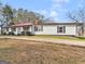 Exterior angle shot of home with white siding, black shutters, and a red metal roof at 1713 Bramlett Shoals Rd, Lawrenceville, GA 30045