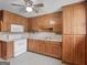 Cozy kitchen featuring oak cabinets, white appliances, and a ceiling fan at 1713 Bramlett Shoals Rd, Lawrenceville, GA 30045