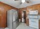 View of the kitchen featuring wooden paneling and stainless steel refrigerator at 1713 Bramlett Shoals Rd, Lawrenceville, GA 30045