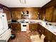 This kitchen features outdated cabinetry, appliances, and damaged floors, clearly requiring renovation at 3210 Rogers Rd, Mcdonough, GA 30252