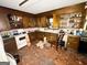 A kitchen shows dated cabinetry, appliances, and cracked flooring, needing remodeling at 3210 Rogers Rd, Mcdonough, GA 30252