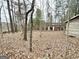 A dilapidated shed surrounded by tall trees and fallen leaves at 3210 Rogers Rd, Mcdonough, GA 30252