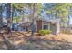 Exterior shot of a charming single-story house, surrounded by mature trees and natural landscaping at 9090 Dorsey Rd, Riverdale, GA 30274