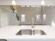 Modern kitchen featuring a stainless steel sink and a view into the living room with large windows at 4853 Walkers Green, Mableton, GA 30126