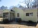 View of the back of the home showing the siding, the enclosed porch, and the trash receptacles at 1989 Grant Sw Rd, Atlanta, GA 30331