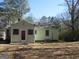 Back of the house showcasing the door, an enclosed porch, and mature trees surrounding the property at 1989 Grant Sw Rd, Atlanta, GA 30331