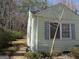 Shows side of home with vinyl siding and bushes around the home on a lot with bare trees at 1989 Grant Sw Rd, Atlanta, GA 30331