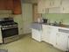 An outdated kitchen features appliances, cabinets and sink in need of repair at 1989 Grant Sw Rd, Atlanta, GA 30331