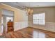 Dining room with hardwood floors, modern chandelier, wainscoting and natural light from window at 227 Lantana Dr, Locust Grove, GA 30248
