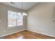 Dining room features hardwood floors, modern chandelier and a window with natural light at 227 Lantana Dr, Locust Grove, GA 30248