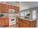 Bright eat-in kitchen features wood cabinets, granite counters, island, and modern white appliances at 227 Lantana Dr, Locust Grove, GA 30248
