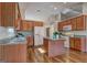 Traditional eat-in kitchen with granite counters, wood cabinets, kitchen island, and stainless steel appliances at 227 Lantana Dr, Locust Grove, GA 30248