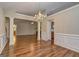 Spacious open concept living room with hardwood floors, modern chandelier and view to eat-in kitchen at 227 Lantana Dr, Locust Grove, GA 30248