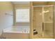 Well-lit bathroom boasts a soaking tub and separate glass-enclosed shower at 227 Lantana Dr, Locust Grove, GA 30248