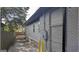 Exterior side view of home with gray brick and siding, showcasing a partial view of the backyard and utility connections at 1528 Olympian Sw Way, Atlanta, GA 30310