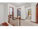 Upstairs hallway with carpet, wooden railing, and views of other rooms at 105 Oak Leaf Ct, Fayetteville, GA 30214