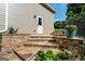 Beautifully landscaped backyard featuring stone steps, a potted plant, and a charming white door at 4185 Etcetera Ln, Cumming, GA 30041