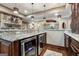 Modern bar area with granite countertop, stainless steel mini-fridges, stone fireplace, and hardwood floors at 4185 Etcetera Ln, Cumming, GA 30041