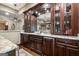 A sophisticated dark wood bar with granite countertop, wine storage, mini-fridge, and mirrored backsplash at 4185 Etcetera Ln, Cumming, GA 30041